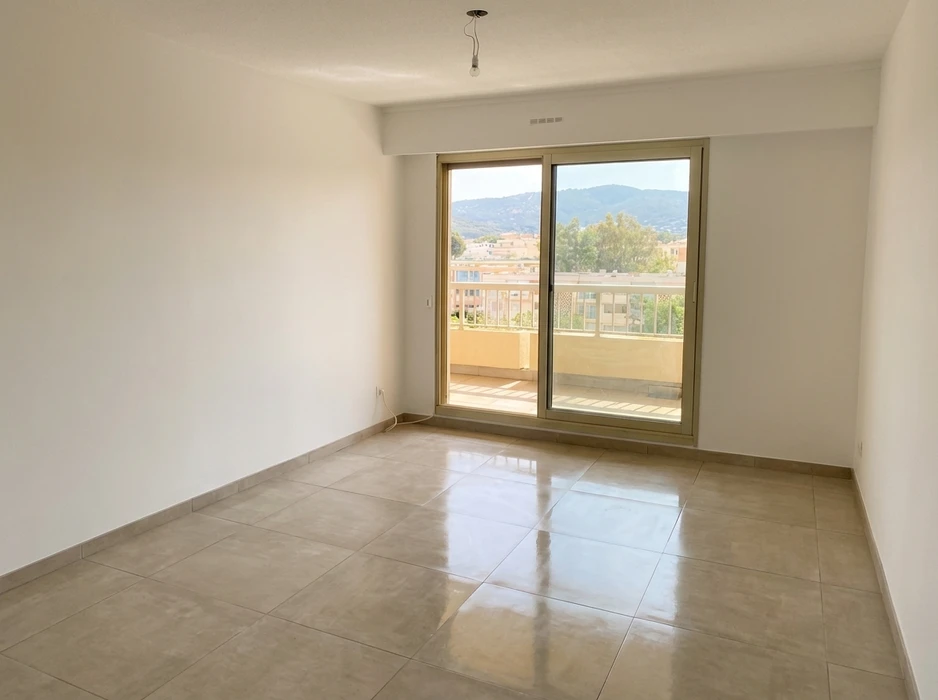 Pièce vide lumineuse avec sol en carrelage grès cérame poli beige, murs blancs, faux plafond avec grille de ventilation