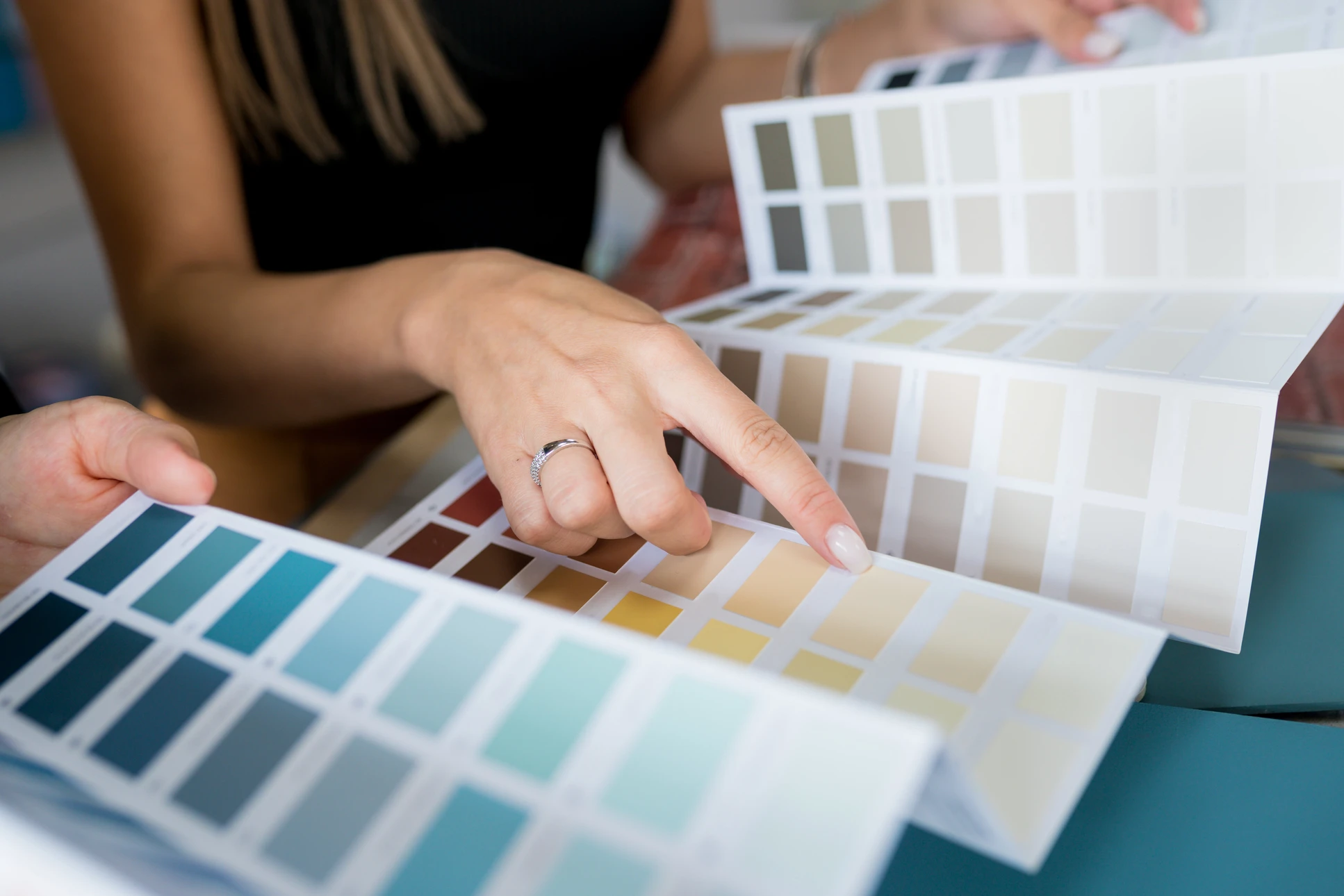 Scène d'intérieur avec une femme consultant des nuanciers de couleurs sur une table