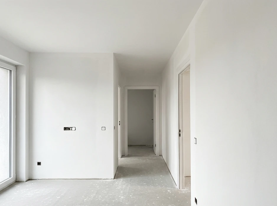 Appartement neuf en cours de finition, couloir et pièces vides aux murs blancs frais enduits
