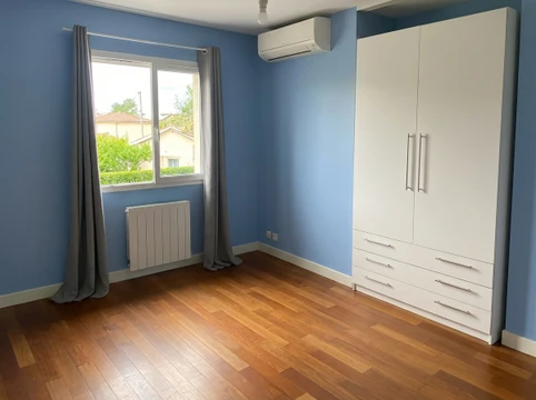 Salle de bain moderne et minimaliste avec WC à réservoir apparent, meuble vasque sur pieds en bois effet chêne avec 2 tiroirs et mitigeur chromé, receveur de douche extra-plat blanc avec colonne de douche réglable à douchette