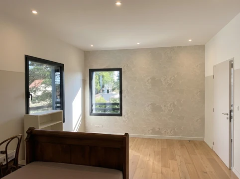 Salle de bain mansardée en cours de rénovation avec carrelage métro blanc partiellement posé, radiateur sèche-serviettes, sanitaires WC et bidet installés