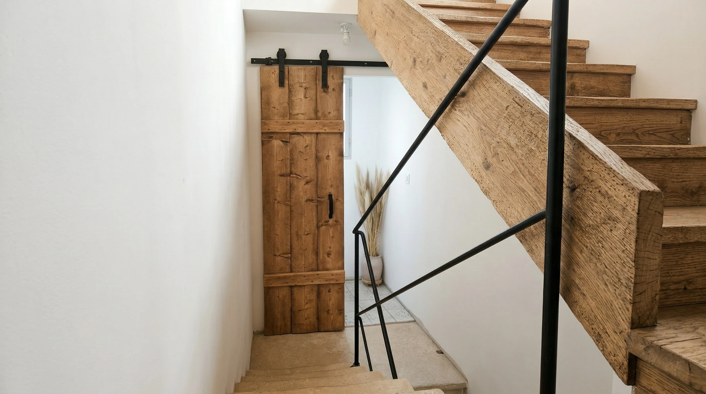 Salle de bain moderne et minimaliste avec WC à réservoir apparent, meuble vasque sur pieds en bois effet chêne avec 2 tiroirs et mitigeur chromé, receveur de douche extra-plat blanc avec colonne de douche réglable à douchette
